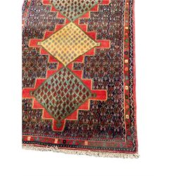Persian Senneh runner, nine geometric medallions linked on red ground, the field decorated all-over with stylised plant motifs
