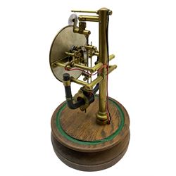 A 1920’s French 800-day Bulle electric battery clock on a turned wooden base, with a circular silvered dial with Arabic numerals, minute track and steel spade hands, skeletonised brass movement and escapement, the magnetic pendulum action is activated by the battery power source located in the base of the clock. No Dome.