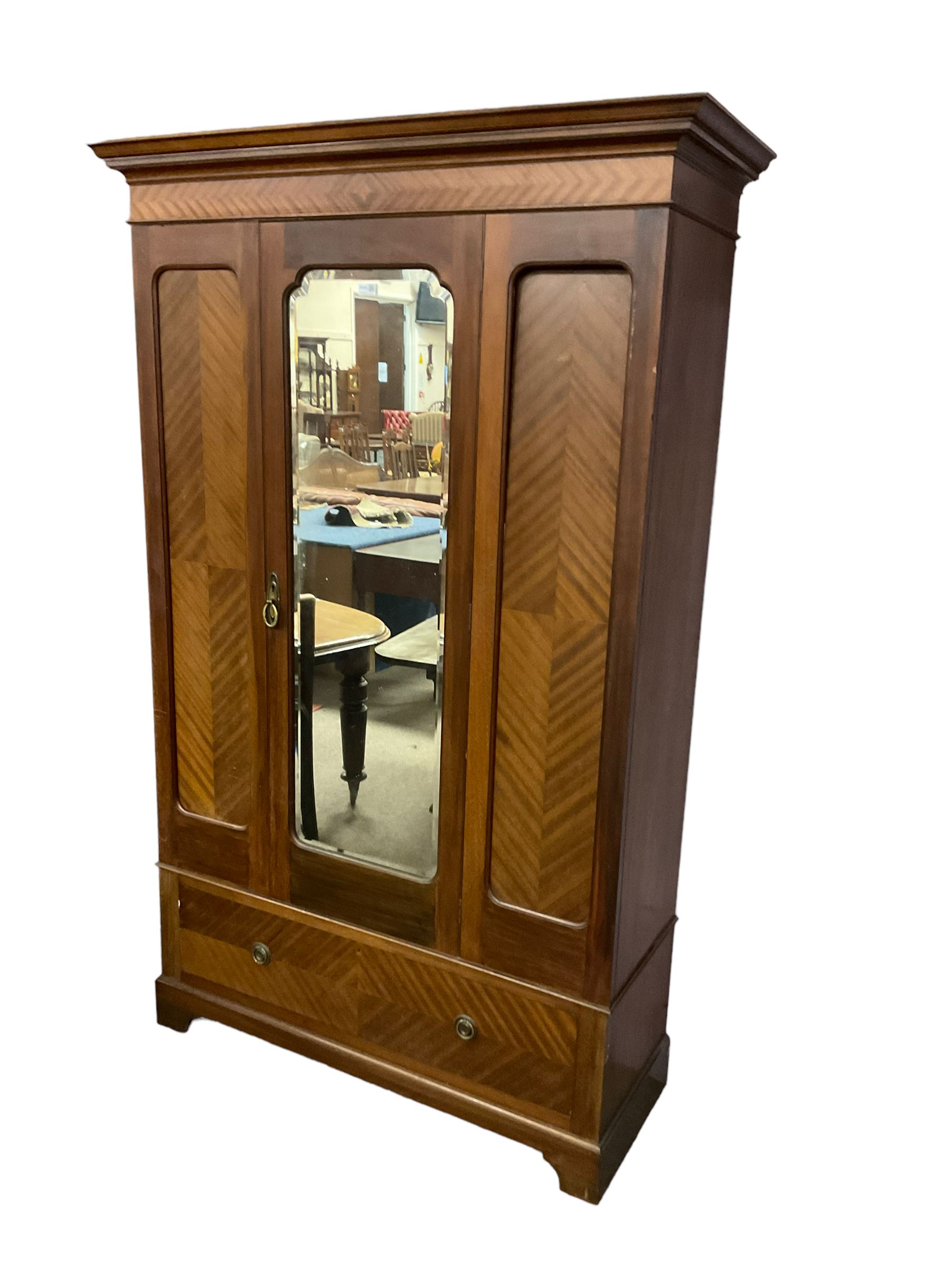 Edwardian mahogany single wardrobe, figured matched veneers to frieze, drawer front and panels, enclosed by bevelled mirror glazed door, base fitted with single drawer, on bracket feet