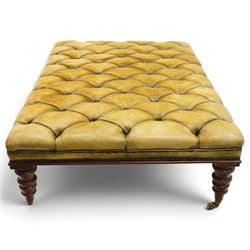 Georgian design footstool of generous proportions, the large rectangular seat upholstered in olive green buttoned leather, raised on heavily turned supports with brass castors