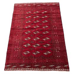 Turkman Bokhara red ground rug, decorated with Gul motifs, repeating guarded border with stylised motifs