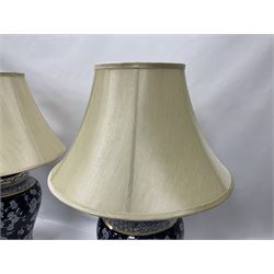 Pair of blue and white table lamps, each of baluster form, decorated with prunus blossom, within stylised borders, raised upon circular gilt base, excluding fittings H48cm