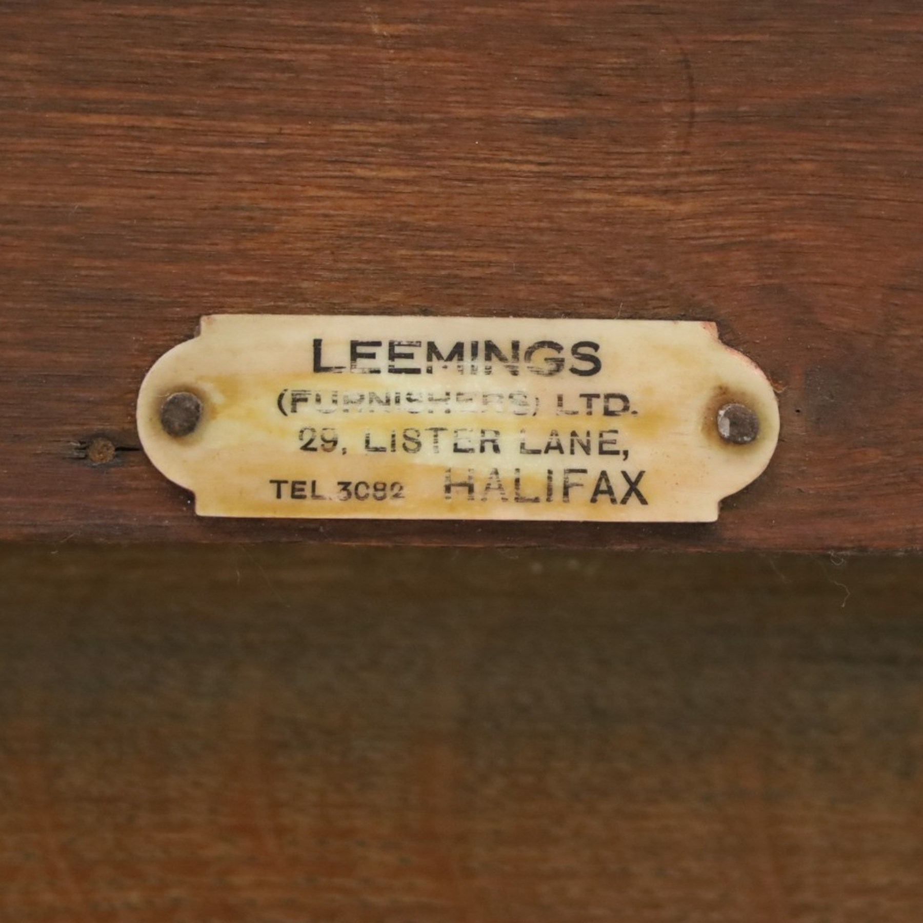 Leemings of Halifax (est. 1872) - Arts & Crafts oak side table, rectangular caddy top with raised moulded back, the frieze carved with central Yorkshire rose motif flanked by two drawers, raised on twin stylised lyre end supports formed of C-scrolls, united by shaped stretcher