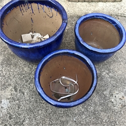 Three large graduating blue glazed terracotta pots, 50cm (max)