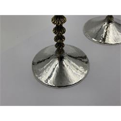 Pair of modern silver goblets by Stuart Devlin, the tapering cylindrical bowls each with spot hammered decoration and gilt interiors, the parcel gilt stems with signature textured detailing and six graduating knops, upon conforming spreading circular foot, hallmarked Stuart Devlin, London 1976, H17.7cm