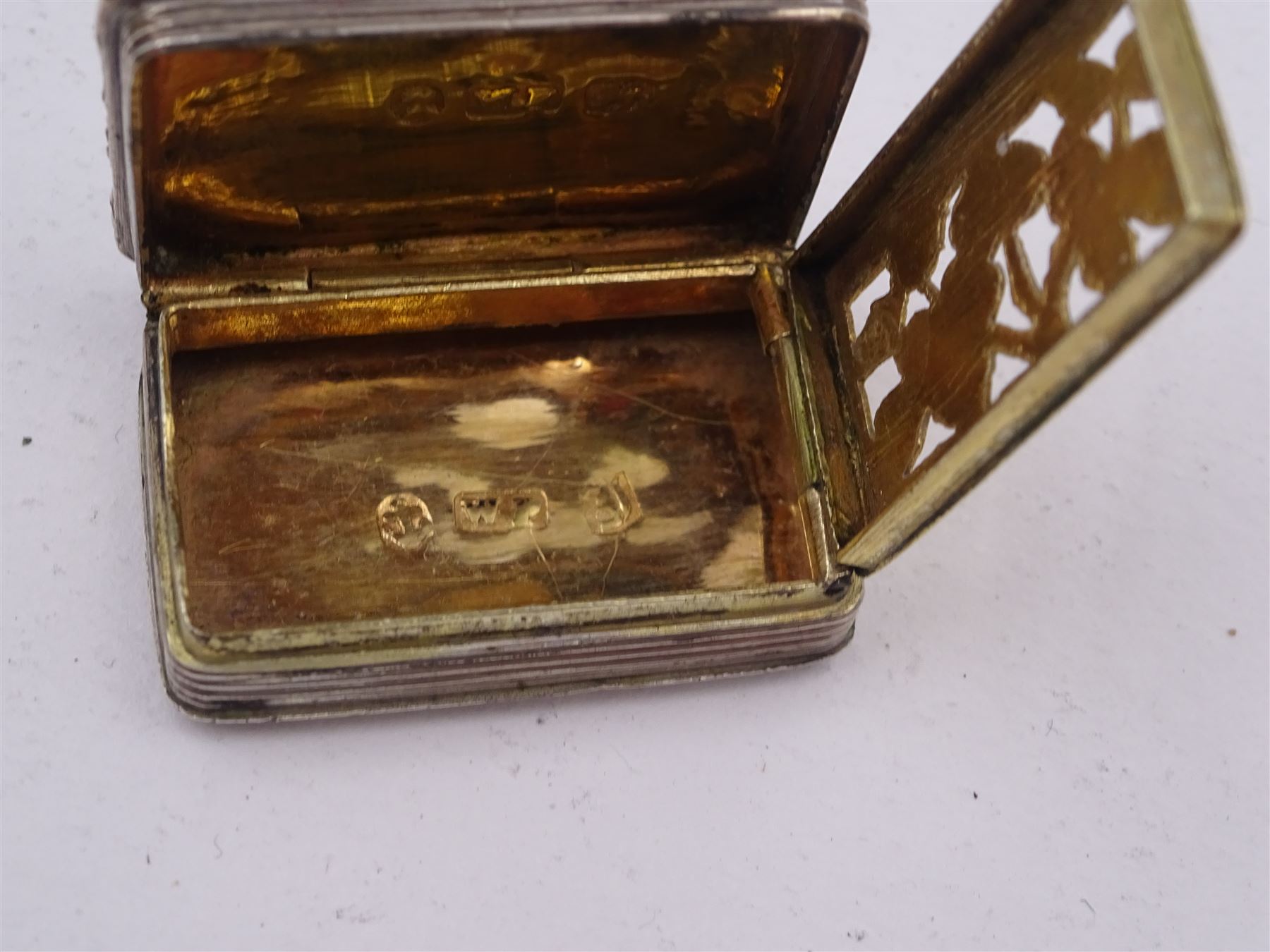 George III silver vinaigrette, of typical rectangular form, with raised foliate rim and engine turned decoration, with banded sides and foliate pierced engraving to gilt interior, hallmarked Birmingham 1797, maker's mark TS, L3cm