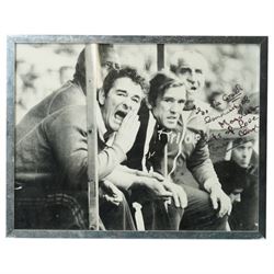 Black and white signed photograph of Brian Clough, Peter Taylor and others in the dugout a...