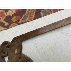 Ikat Man’s Cloth (Hinggi Kombu), East Sumba, Indonesia, woven in red, blue and yellow-brown warp ikat, constructed of two mirroring long panels, the motifs arranged in four bands depicting warrior figures astride rearing horses, high-ranking figures and guardians within geometric borders, on carved wooden wall hanger, L295cm
