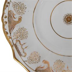 Late 19th century tea service, decorated in gilt with bands of seaweed type tendrils, thistles and cross hatch reserves upon a white glazed ground, comprising tea pot, twin handle lidded sucrier, milk jug, slop bowl, three serving plates, twelve cups and saucers and eleven side plates