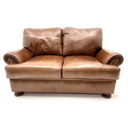 Three seat studded tan leather sofa, scrolling arms, turned supports (W190cm) with matching two seat (W155cm) armchair (W100cm) and footstool 