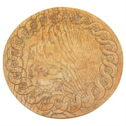 Gnomeman - oak circular stool, the top carved with continuous rosette and scrolling border, raised on three splayed supports, one leg carved with gnome signature, by Thomas Whittaker of Littlebeck