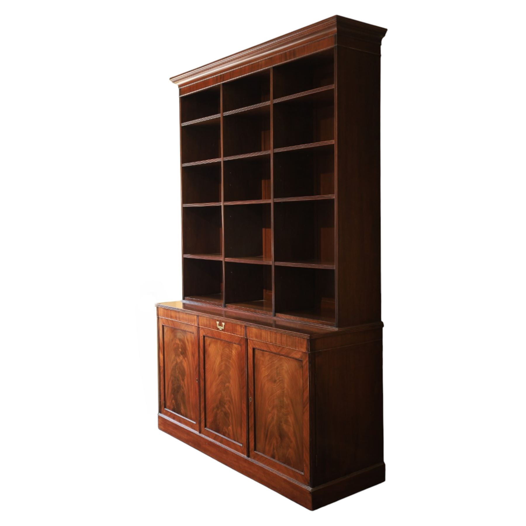 Early 20th century mahogany open bookcase, with reeded upright divisions and adjustable shelves, over a cupboard base fitted with three frieze drawers and three panelled doors, on plinth base