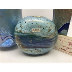 Two Isle of White glass vases, by Alum Bay Glass, both with blue swirl design upon an iridescent mottled blue/green ground, together with a Gozo Glass vase of pebble form, with similar design, H12cm