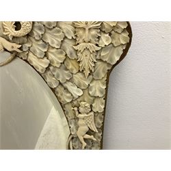 Pair 19th century French Dieppe bone and ivory wall mirrors, the oval bevelled mirror plates within rectangular frames with shaped tops, profusely decorated with ivory leaves, further detailed with carved bone armorial type crest inscribed 'SGOTORVM', putti, fish and mask heads, H81cm W48cm