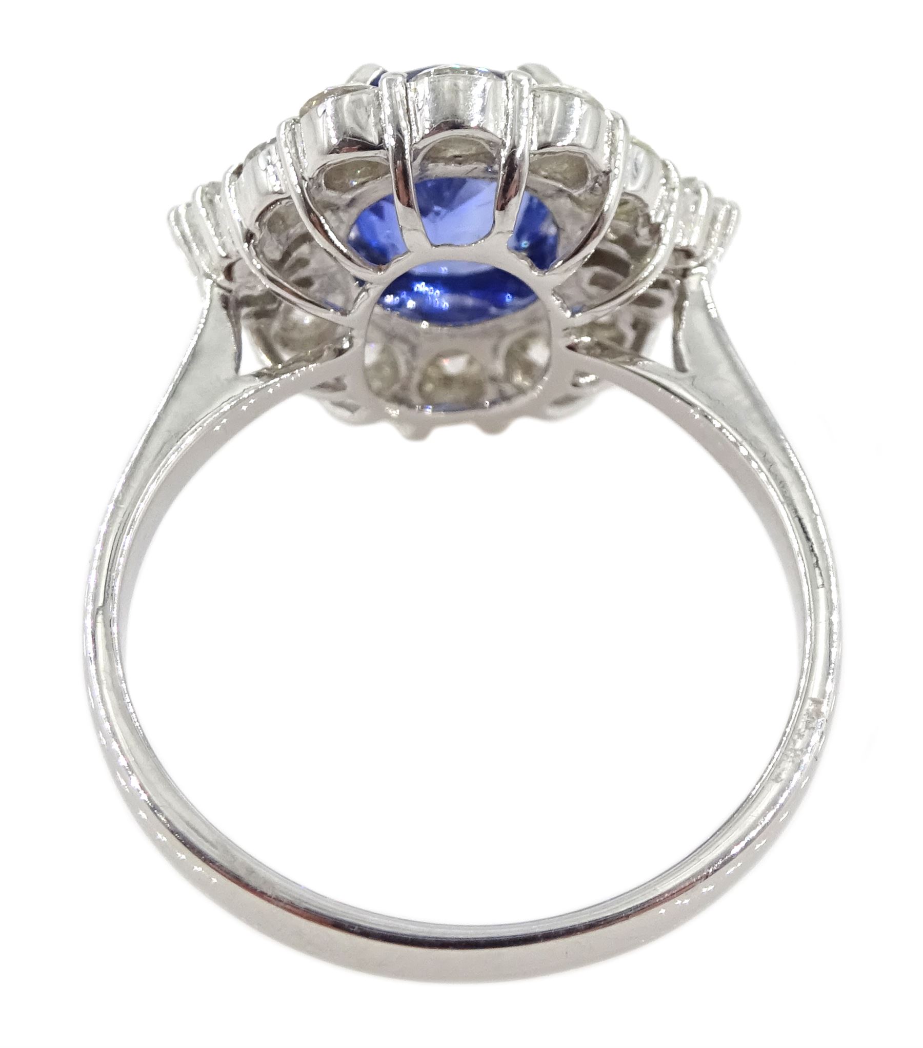 18ct white gold sapphire and diamond cluster ring, the central oval sapphire of approx 2.10 carat, with tapered baguette diamonds and round brilliant cut diamond surround, stamped 750