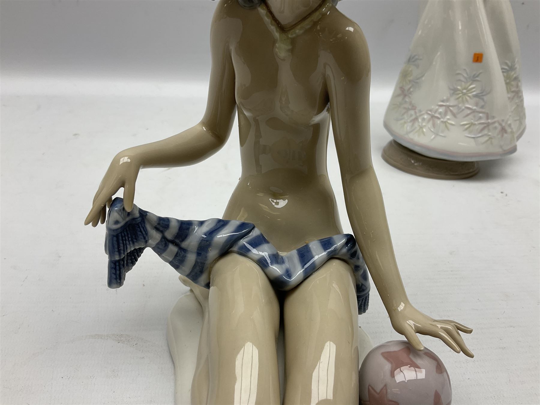 Three Lladro figures, comprising Modern Mother no 5873, Dropping the Flowers no 1285 and On the Beach no 1481, all with original boxes, largest example H30cm