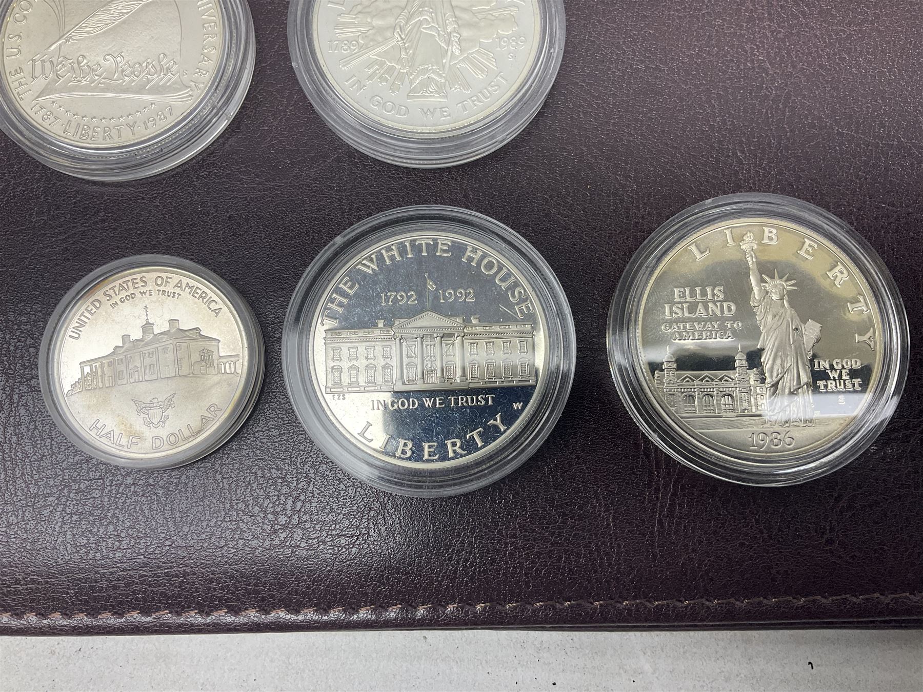 Five United States of America commemorative silver proof coins, comprising 1986, 1987, 1989, 1992 one dollars and 1982 half dollar, all with certificates