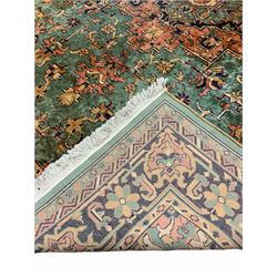 Persian style green ground rug carpet, large central medallion surround by geometric design and stylised flower heads, four band border 