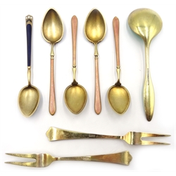  Two Norwegian silver-gilt and enamel serving forks by David Anderson, four Norwegian silver-gilt and enamel coffee spoons, with still life of fruit decoration by Henry James Hulbert, import marks, London 1925, one other by same maker and one other similar spoon stamped Frigast sterling Denmark (8)  