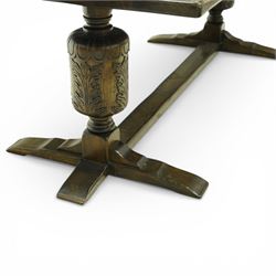 20th century oak refectory style dining table and eight chairs (6 + 2), rectangular top on two large carved baluster pedestal supports with leaf decoration, on splayed trestle bases joined by a stretcher, with eight matching oak dining chairs, each with Yorkshire rose carved cresting rail, panel back and solid seat, raised on turned supports united by stretchers