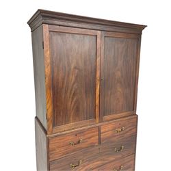 George III mahogany Gentleman's linen press, the projecting cornice over two panelled cupboard doors enclosing three sliding trays, the base fitted with two short over three long graduating cock-beaded drawers, lower moulded edge over bracket feet