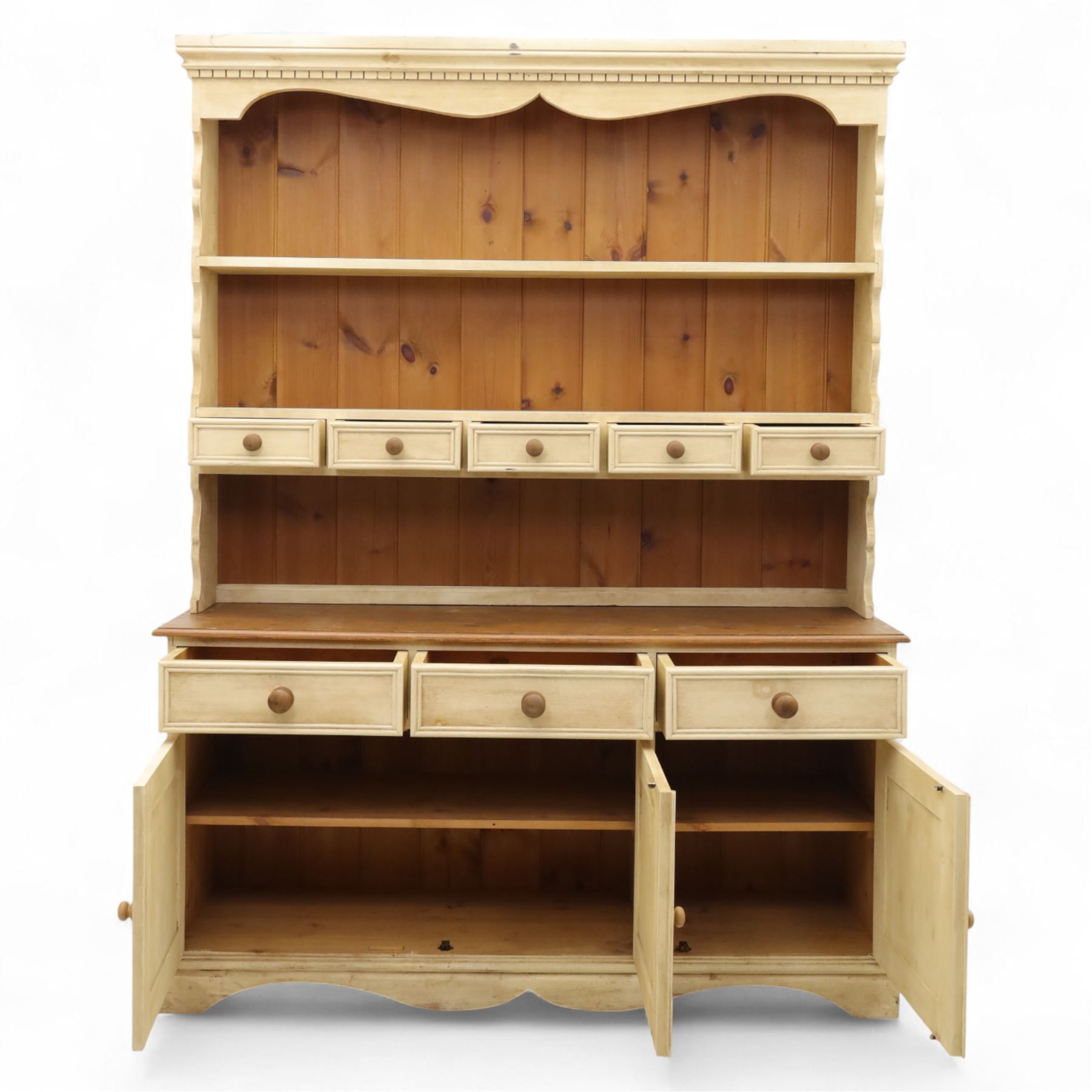 20th century painted pine dresser, moulded cornice above shaped frieze and two open plate shelves, central row of five small drawers with wooden knobs, base fitted with three drawers over a pair of panelled cupboard doors, on shaped plinth base