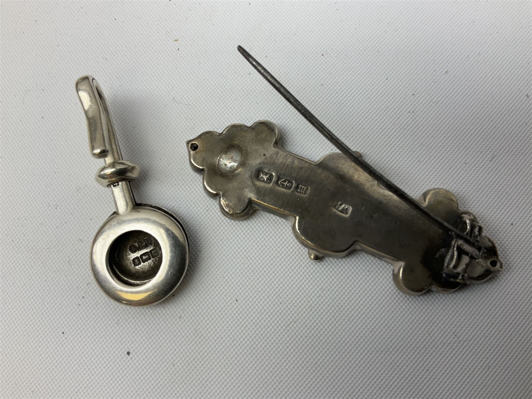 Group of silver, to include filled figure of a pheasant, hallmarked for London, pair of silver mounted horn napkin rings, miniature Edwardian bible with silver cover embossed with putti, Victorian silver brooch, ebonised plinth with applied inscribed silver shields, etc., together with two stick pins, one example with 9ct gold terminal 