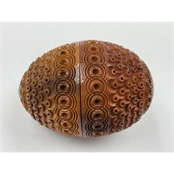 Three 19th century coquilla nut pomanders or flea catchers, two of egg shaped form and the third of barrel from with carved and pierced decoration and screw threaded join, largest H8cm