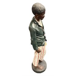 Plaster cast figure of a young boy holding a polishing rag, on circular base 
