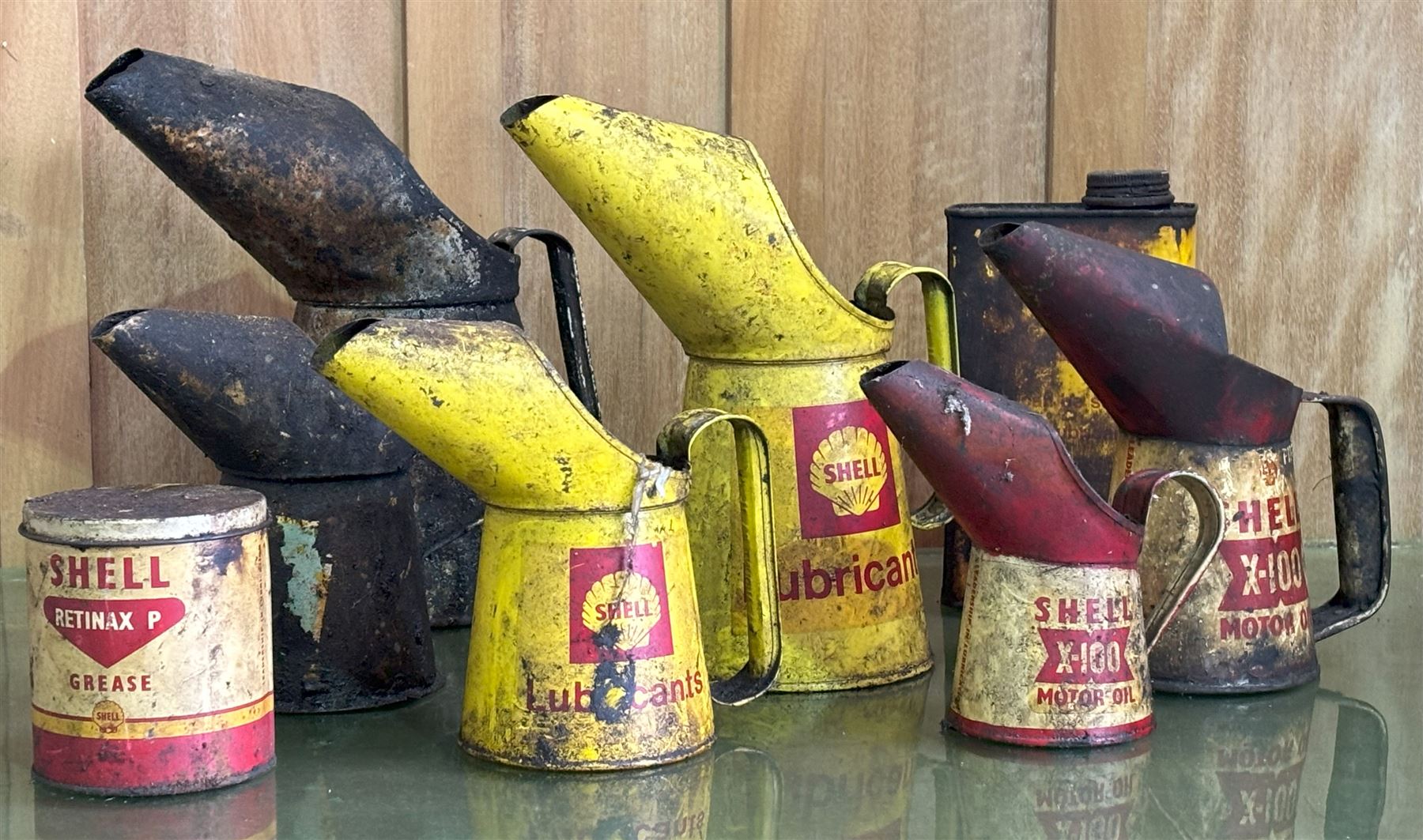 Graduated pair of Shell lubricants oil pourers, together with a graduated pair of Shell X-100 oil pourers, a Shell grease tin, a Shell motor oil tin, a BP Lubricants oil pourer, and another (8) - COLLECTION BY APPOINTMENT FROM: The White House, Thirsk Road, Easingwold, York, YO61 3NF - CALL 01723 507111 TO ARRANGE