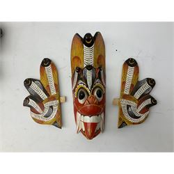 Sri Lankan Cobra mask depicting the demon Naga Raksha, together with a smaller example, largest H46cm