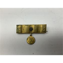 Two WW2 German Army Afrika Korps pith helmet metal side badges; RAD oval metal badge by J.B.u.Co.; WW1 German 1914-1915 bar brooch; and Nienburg War Veteren's Association badge (5)