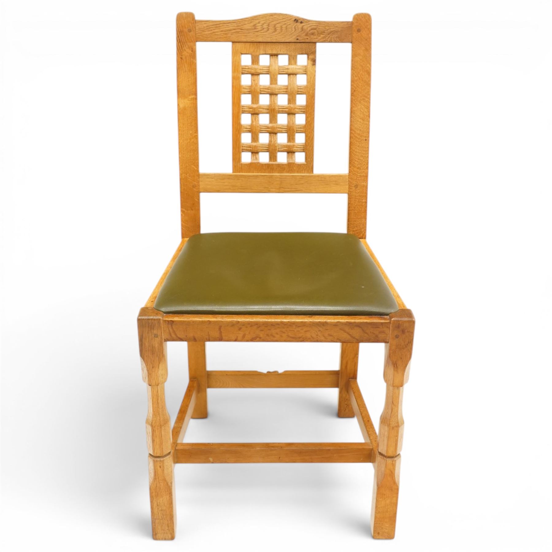 Beaverman - 1980s set of four lattice back dining chairs, shaped top rail above a lattice back, green leather fixed seat, raised on octagonal front supports, with carved Beaver to the back stretcher, by Colin Almack of Sutton near Thirsk