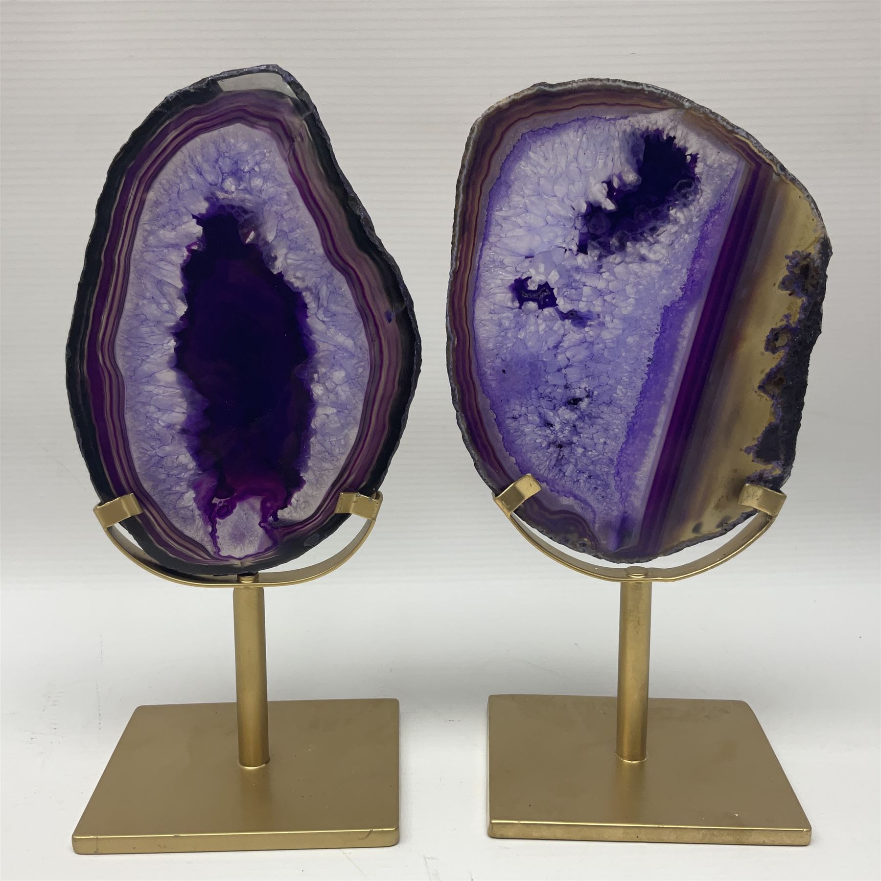 Pair of purple agate slices, polished with rough edges raised upon gilt metal stands