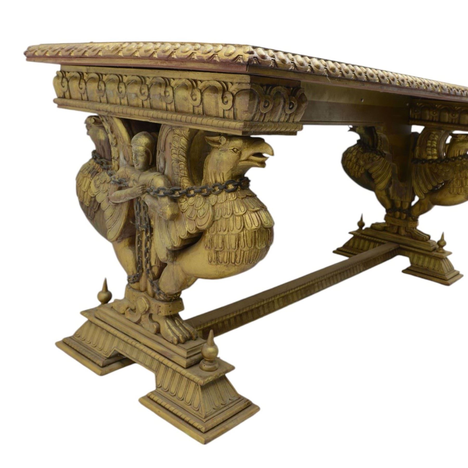 19th century Renaissance Revival carved and giltwood centre table, the rectangular top with gadrooned edge and carved frieze of repeating arched motifs with stylised scrolls, supported by a pair of carved winged griffin supports restrained by a central chained figure, on stepped rectangular bases united by carved stretcher
