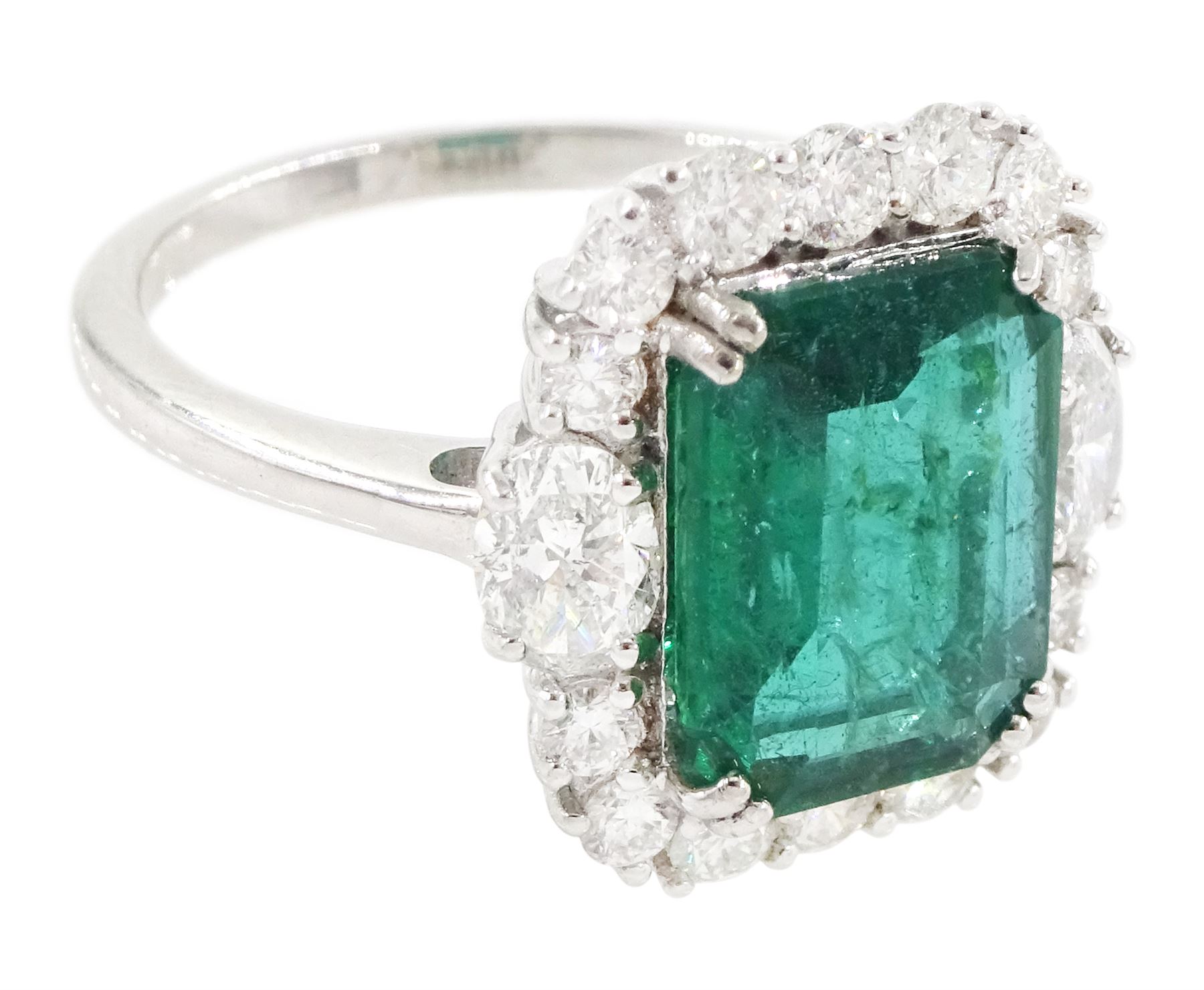 18ct white gold emerald and diamond cluster ring, the octagonal cut emerald of approx 2.85 carat, with an oval cut diamond set either side and round brilliant cut diamond surround, stamped, total diamond weight approx 1.05 carat