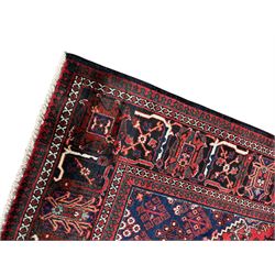 Persian Joshaghan crimson ground rug, stepped lozenge medallion surrounded by repeating foliate lozenge motifs, the border decorated with stylised plant motifs, within geometric guard stripes