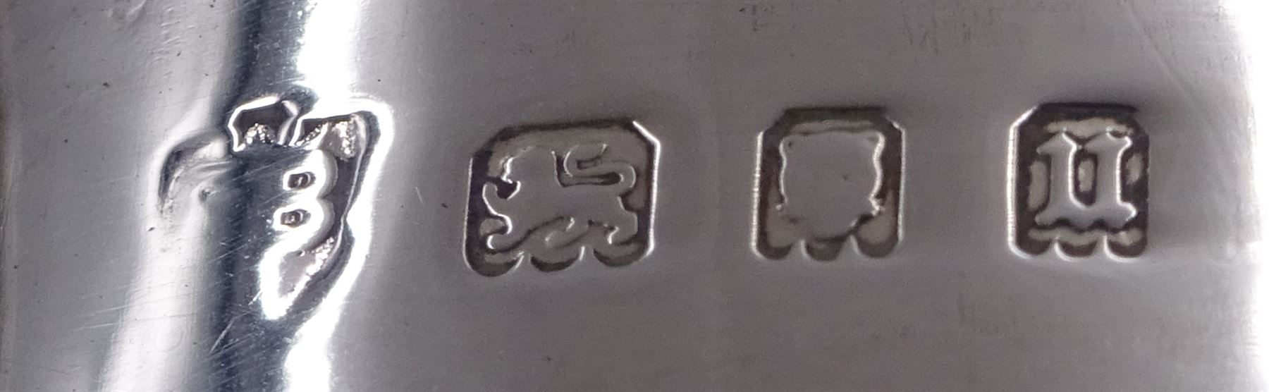 1930s silver part cruet set, comprising mustard pot and cover and open salt, both of circular drum form with oblique gadrooned rim, the mustard pot with capped scroll handle and palmette thumbpiece, both with blue glass liners, hallmarked London 1935, maker's mark worn and indistinct