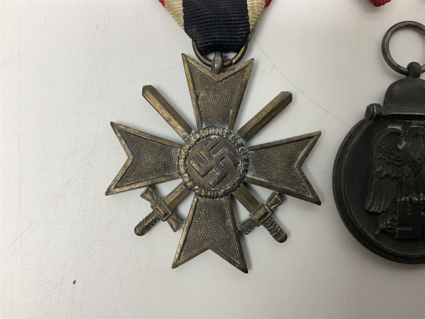 WW2 German Eastern Front Medal awarded to those who served on the German Eastern/Russian Front during the Winter Campaign period of 15th November 1941 to 15th April 1942 with original ribbon; German War Merit Cross with swords; and NSDAP Long Service Award (3)