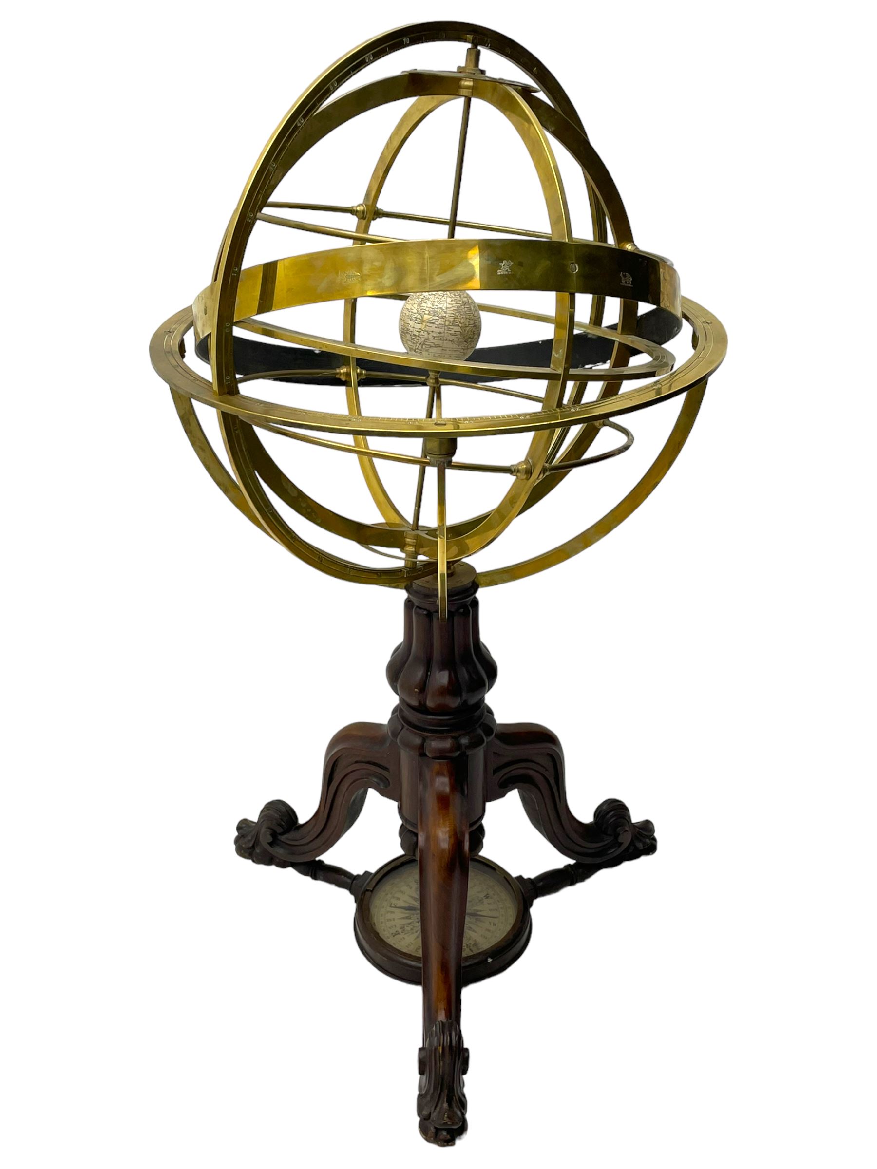 19th century brass terrestrial armillary sphere on rosewood base, lobe carved column on three splayed supports with scrolled carved terminals, the supports united by circular compass with turned stretchers