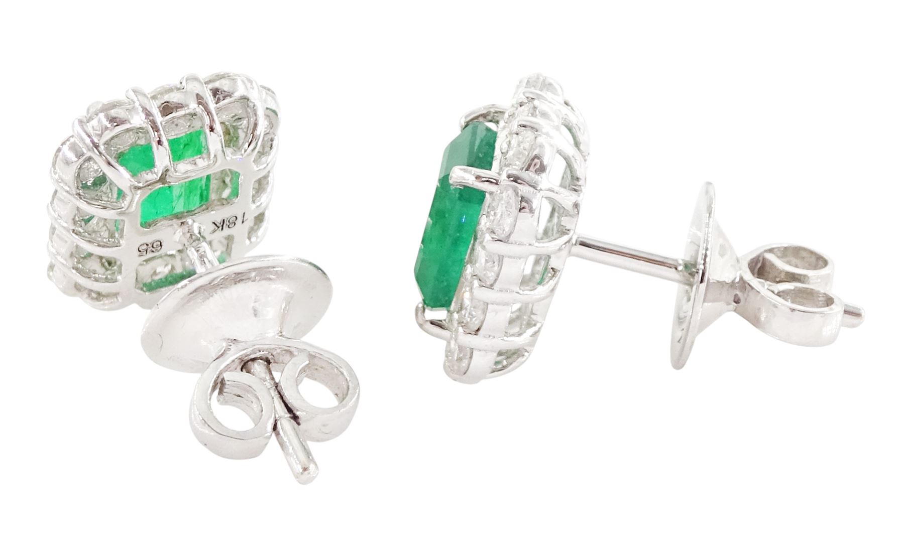 Pair of 18ct white gold emerald and diamond cluster earrings, each stud set with a single octagonal cut emerald, with round brilliant cut diamond surround, stamped, total emerald weight approx 1.30 carat, total diamond weight approx 0.70 carat