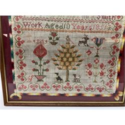Early Victorian sampler, worked by Anglina Smith Aged 10, dated 1851, depicting tree surmounted by a bird, flanked by a dog and cat, and various motifs including flowering urns, underneath rows of alphabet, within a strawberry vine border, framed and glazed, overall H42cm W38cm
