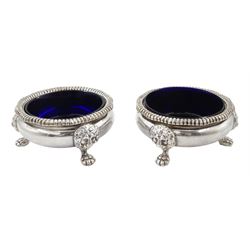 Pair of early 20th century Georgian style silver open salts, of cauldron form with gadrooned rims, upon three lion mask and paw feet, with blue glass liners, hallmarked Adie Brothers Ltd, Birmingham 1934, H3.5cm D7cm, gross weight exclusive of liners 7.84 ozt (244 grams)