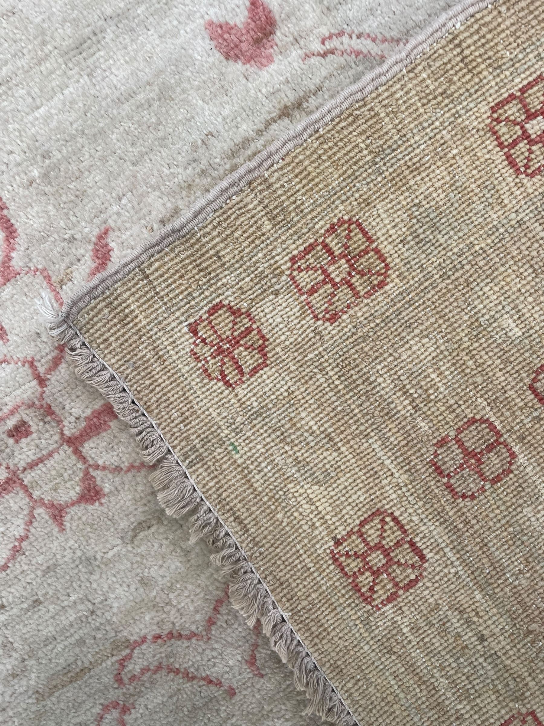 Persian design pale ivory ground carpet, decorated with stylised plant and leaf motifs in pale red