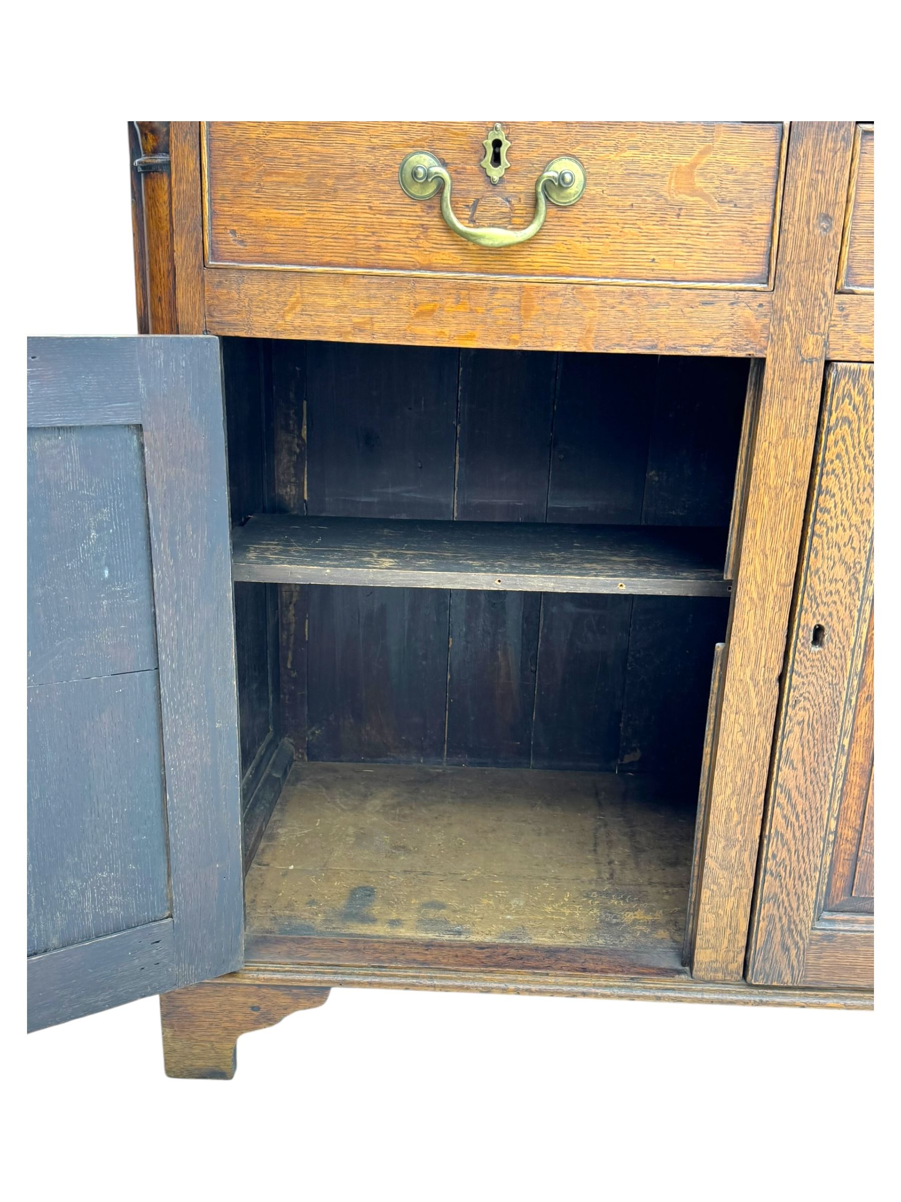 19th century and later oak dresser, moulding cornice a pierced and shaped frieze, over two open plate shelves above a base fitted with two drawers with brass swan neck handles, over panelled twin cupboard with single shelf, cantered corners on bracket feet