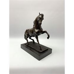 Bronze figure modelled as a prancing horse, upon a naturalistically modelled rectangular base, and black marble plinth, H34.5cm, L31cm