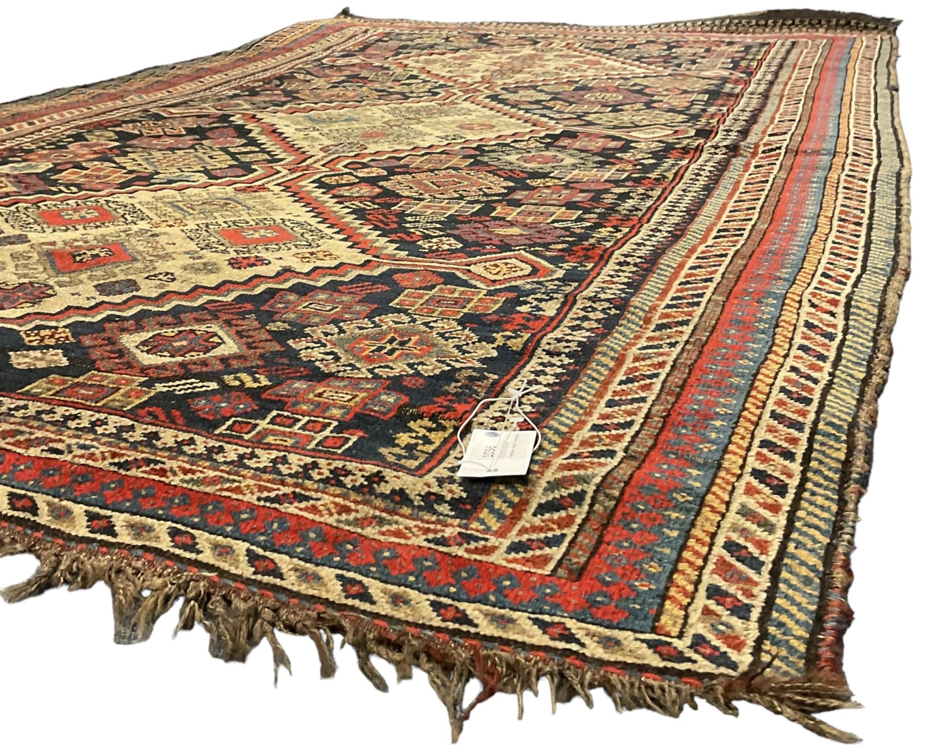 Old Persian Hamadan rug, the indigo ground field with three interlinked lozenge medallions, decorated all over with geometric and stylised motifs, eight band border with repeating geometric patterns 