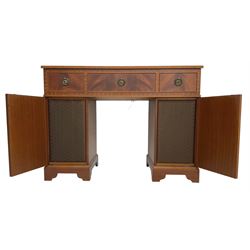 Music system in the form of a Georgian design twin pedestal desk, the reed moulded rectangular top hinges to reveal Garrard turntable with Dynatron Amplifier, fitted with speakers enclosed by two doors disguised as drawers, on bracket feet