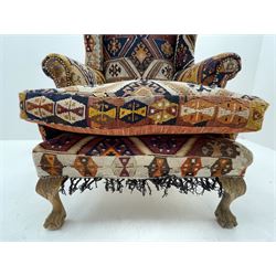 Late 20th century beech framed wingback armchair, sprung seat and back upholstered in kilim cover, acanthus carved cabriole supports with ball and claw feet