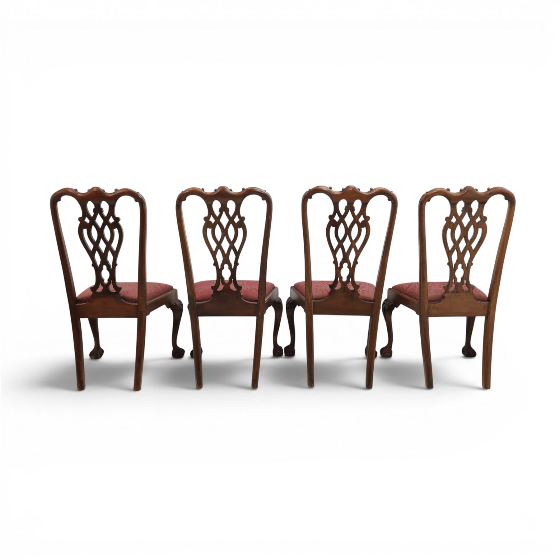 Chippendale design set of ten (8+2) mahogany dining chairs, serpentine cresting rails with carved detail over pierced ribbon-tied splats, red damask upholstered drop-in seats, on cabriole supports with acanthus carved knees and claw and ball feet